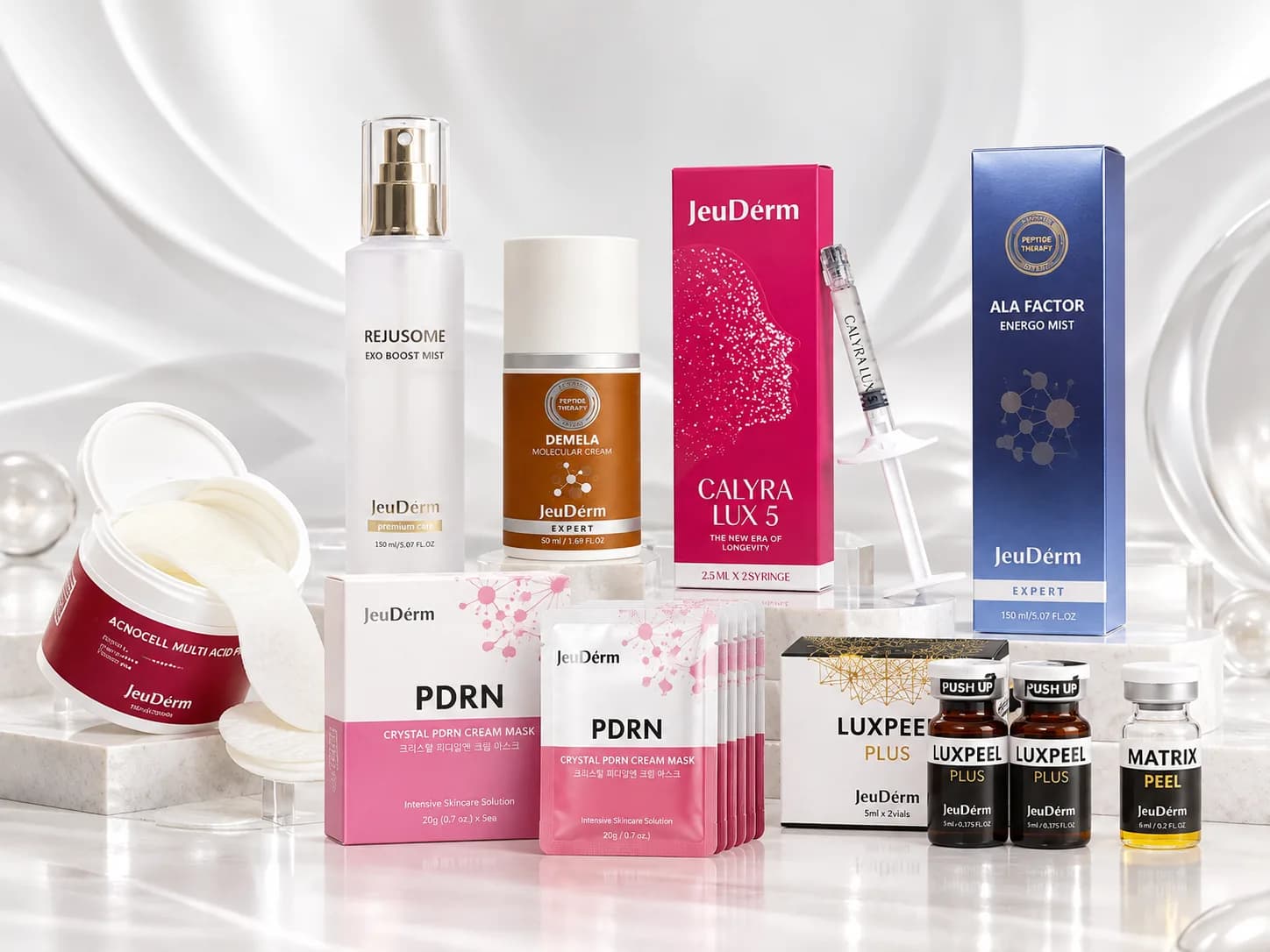 JeuDérm-Produkte auf hellem Marmor, von Acnocell Multi-Acid Pad und Crystal PDRN Cream Mask bis Calyra Lux 5 und LuxPeel Plus